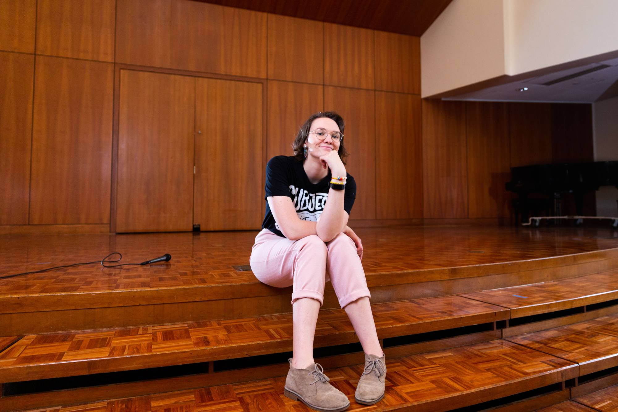 Student sits on stage in the Cook-Dewitt Center